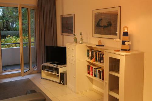 Langeoog Ferienwohnung Langeooger Jahreszeiten - Wohnraum: Medien, Tür zum Balkon