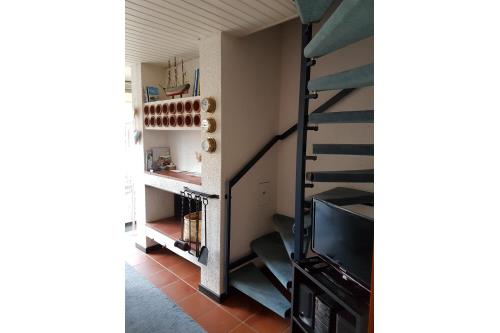 Langeoog Ferienhaus Schäfer - Wohnraum: Kamin, Treppenaufgang zum 1.OG